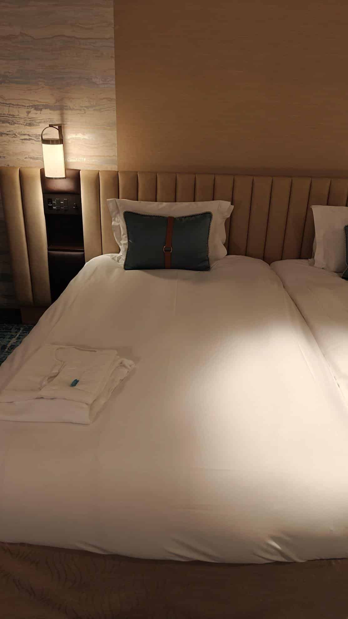 Cozy hotel bed with cushion and robe