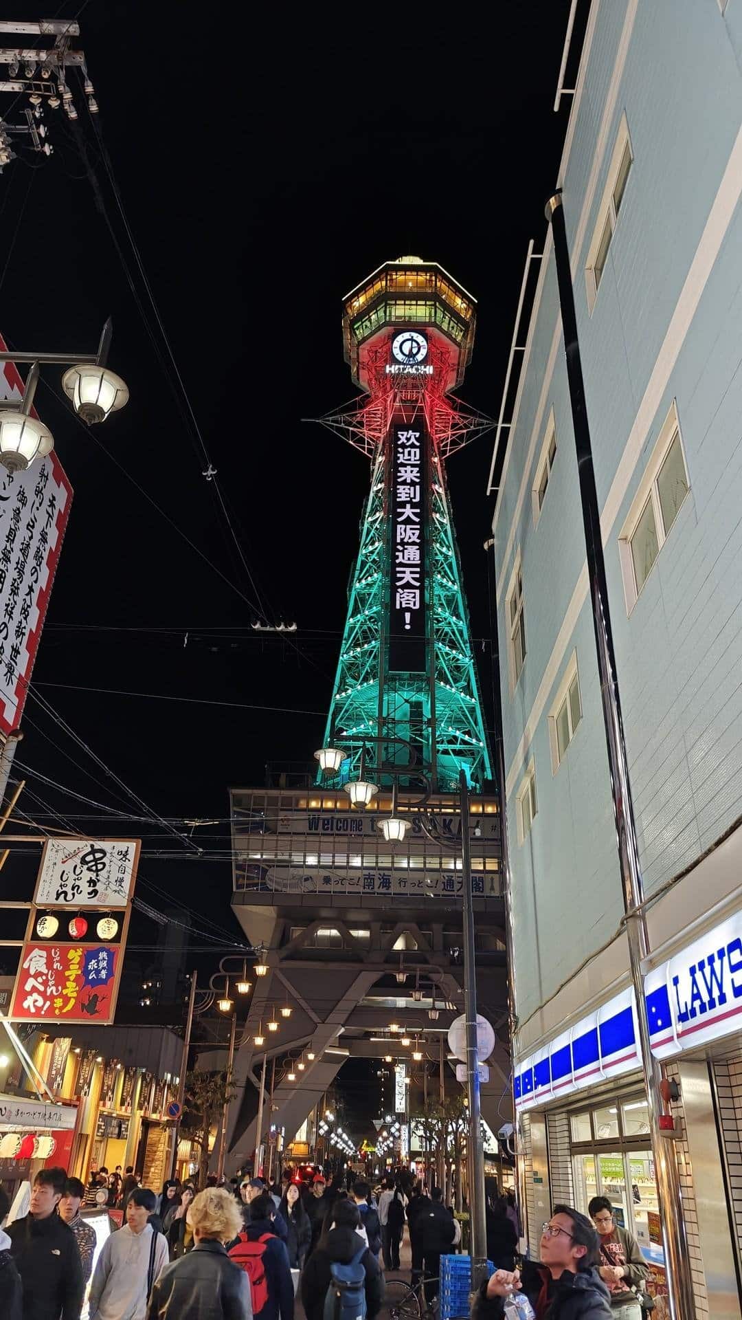 Crowded night under illuminated tower