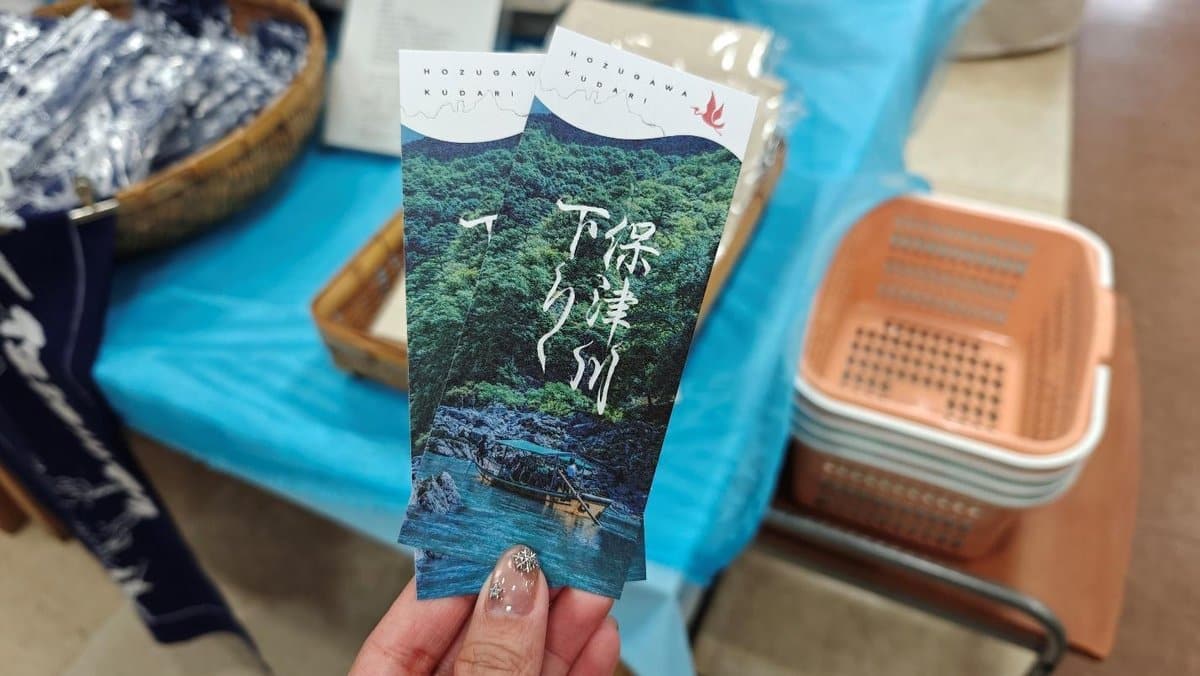 Hand holding brochures with scenic river and boat image