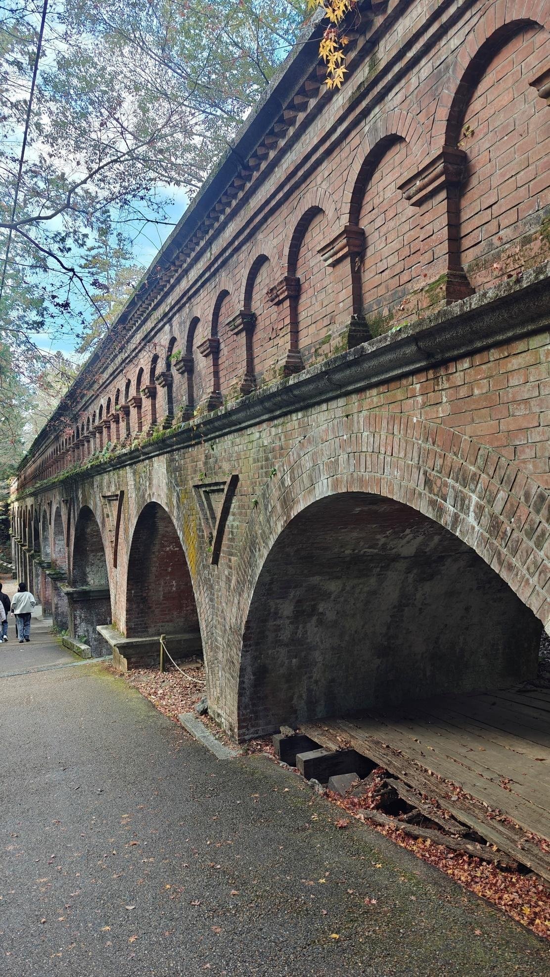 Historic brick aqueduct with arches in a forest setting
