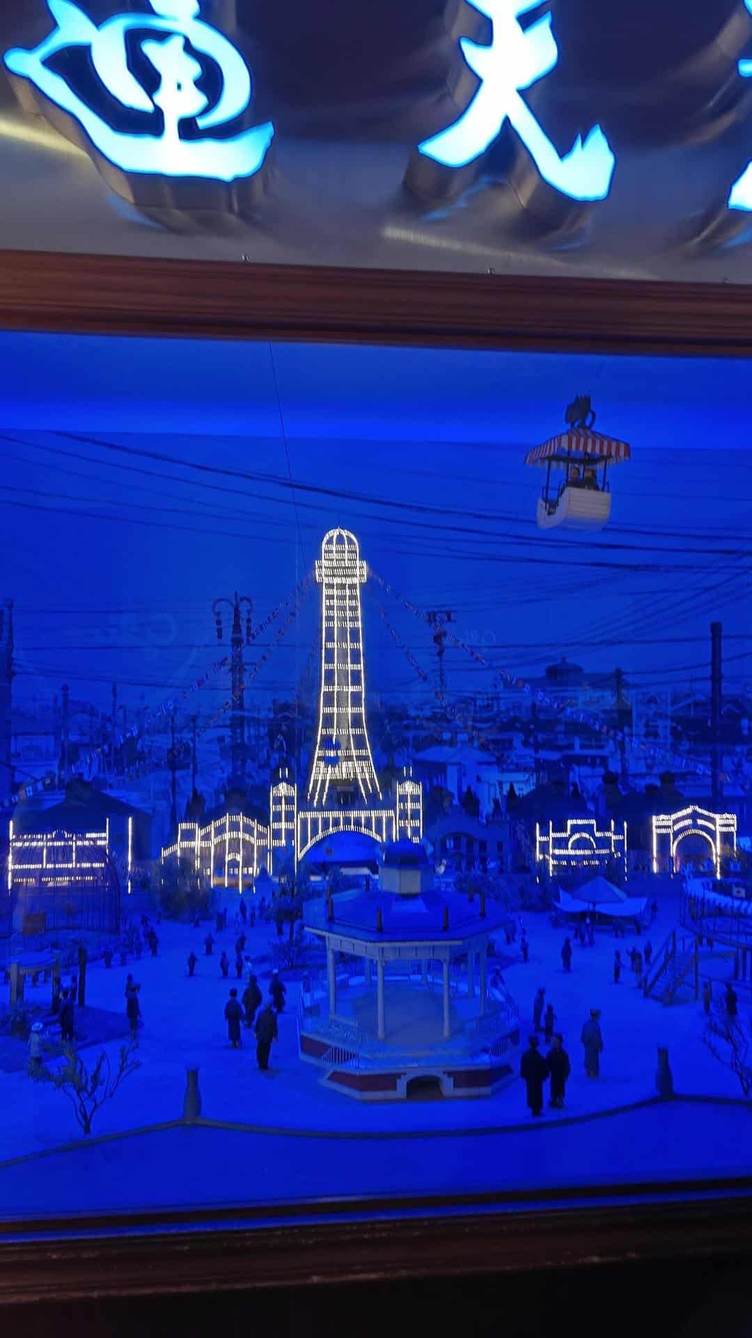 Illuminated model of tower with figures