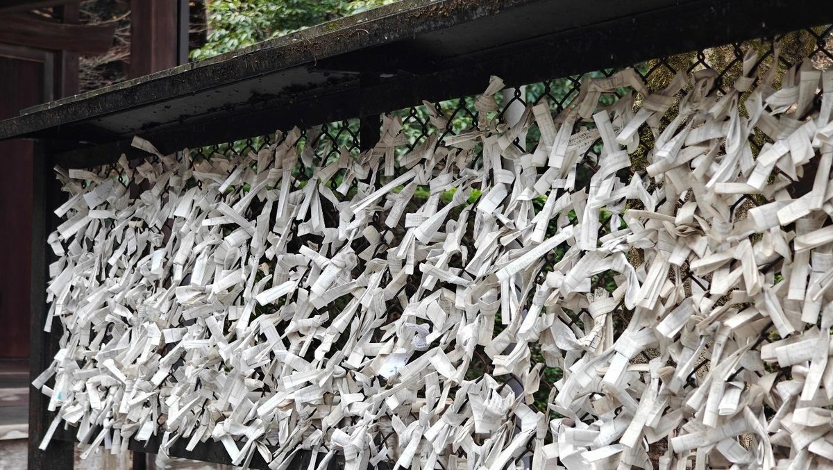 Japanese fortune papers tied to a shrine fence