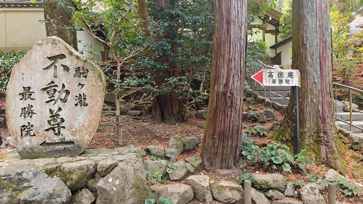 Japanese stone marker near forest path and staircase