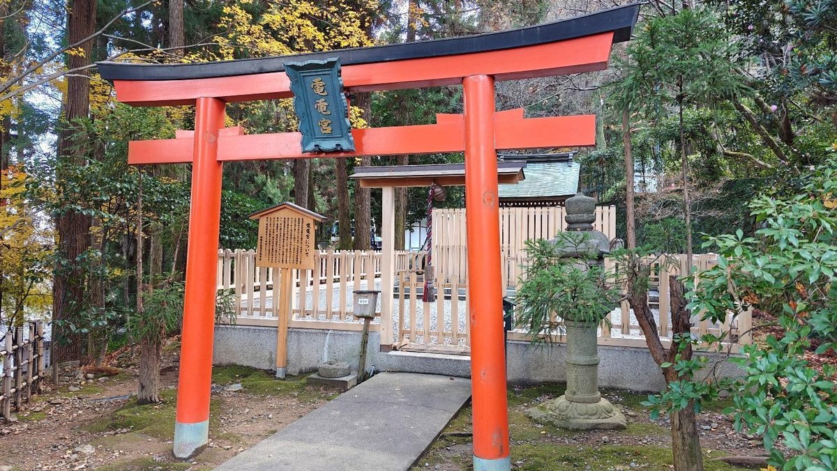 Japanese torii gate amidst forest scenery