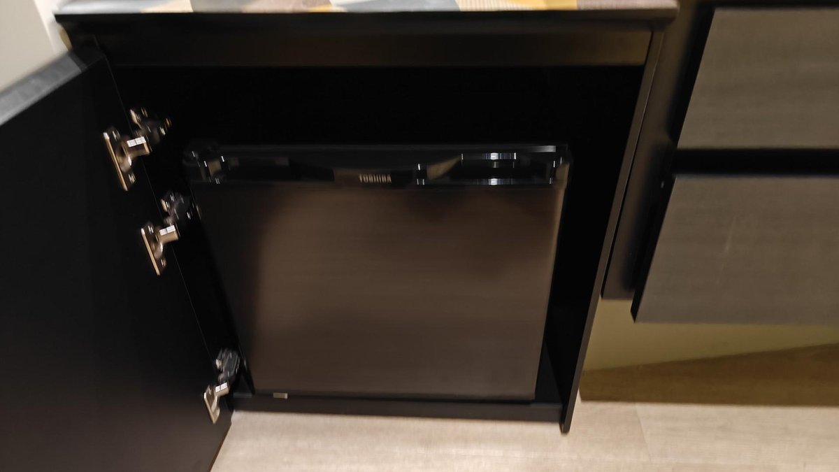 Mini fridge in open cabinet
