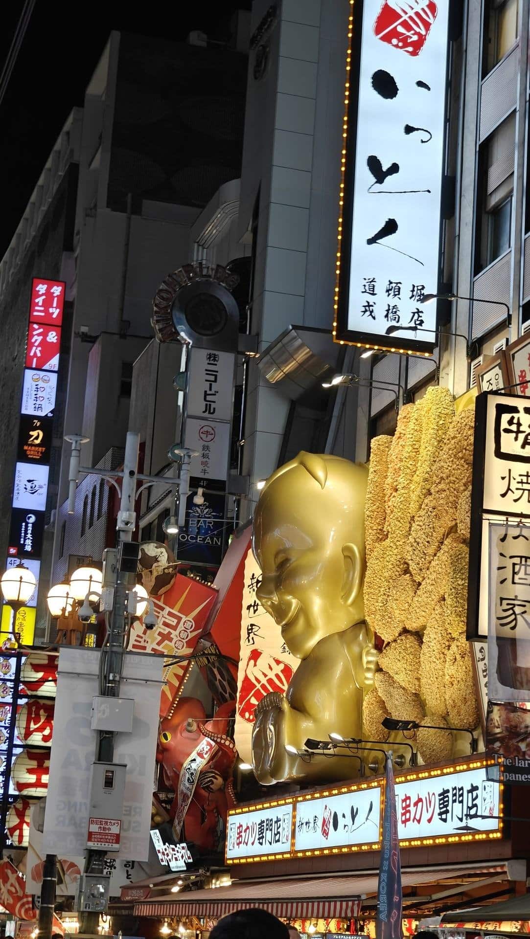 Neon signs and golden statue at night