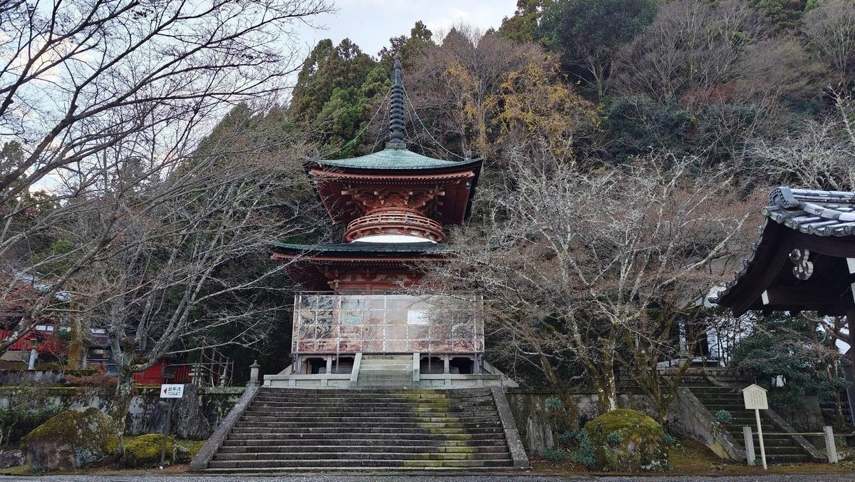 Pagoda surrounded by barren trees and lush forest
