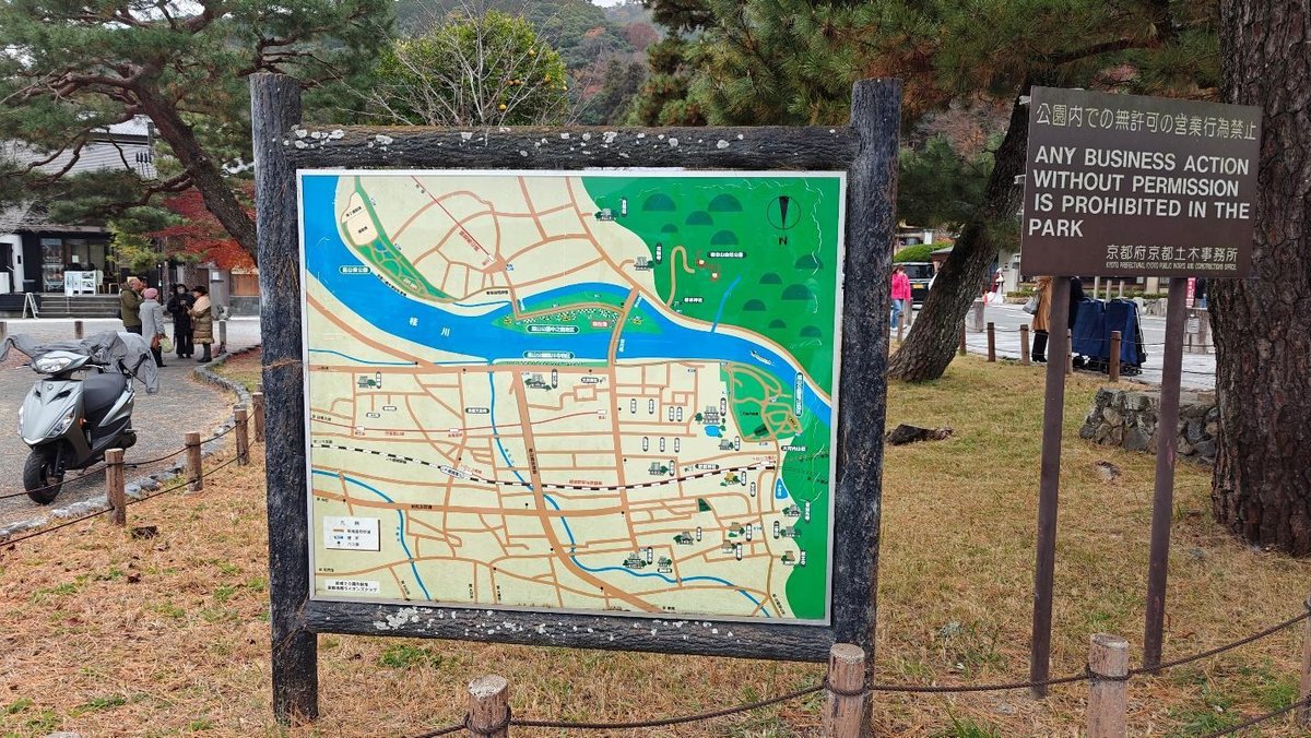 Park map on sign with people and trees in background