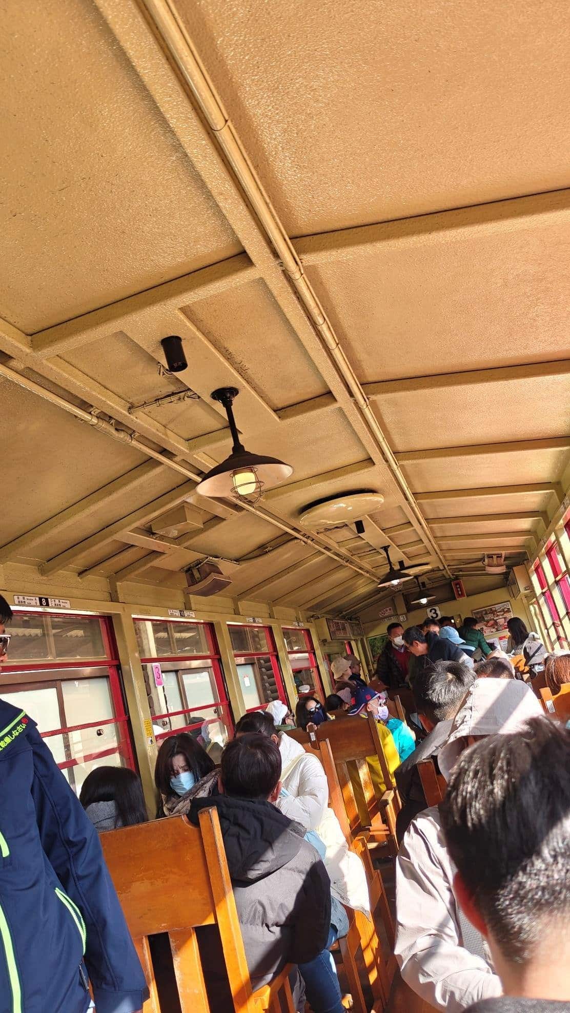 Passengers seated in a sunlit train carriage