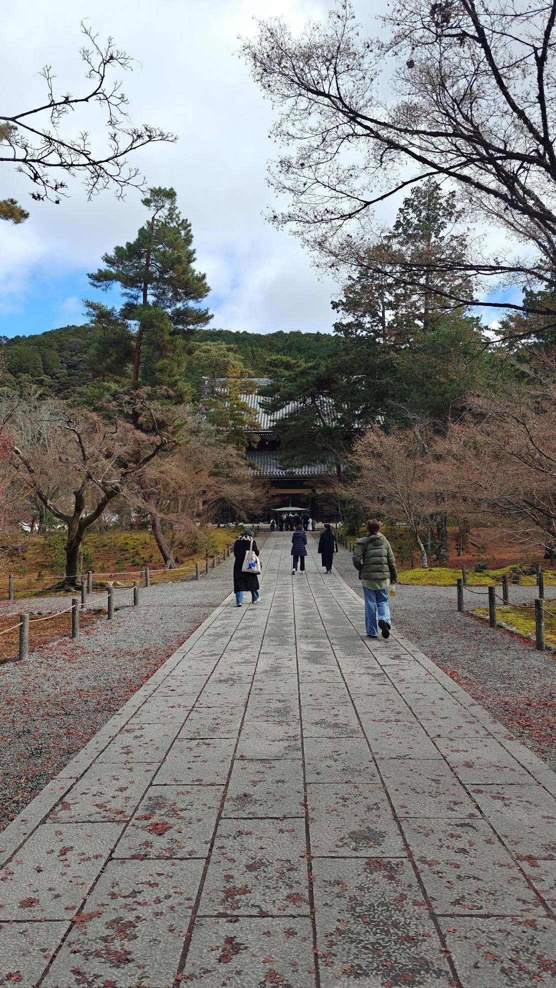 Pathway in temple garden with trees and visitors