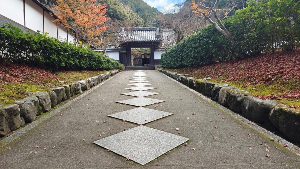 Pathway to traditional gate with autumn foliage