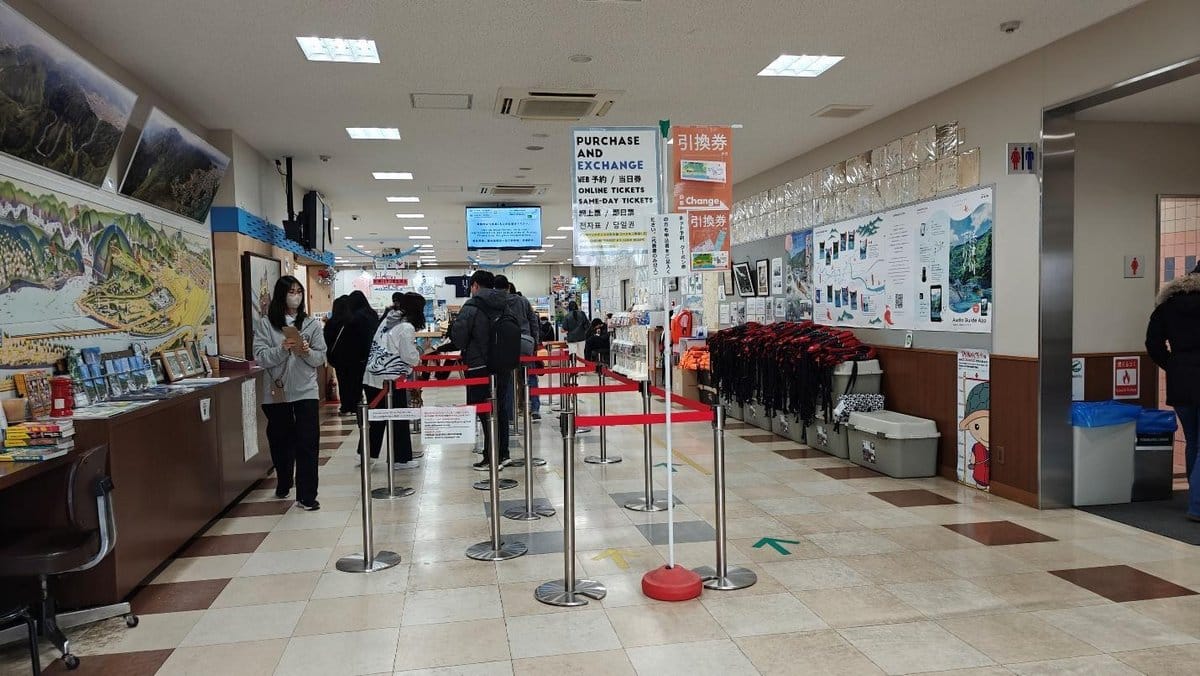 People queuing at a ticket counter in a modern office
