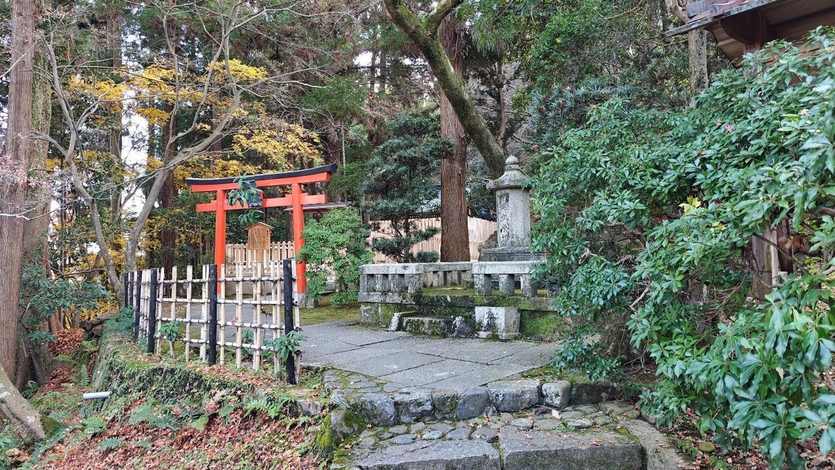 Red torii gate in lush forest setting