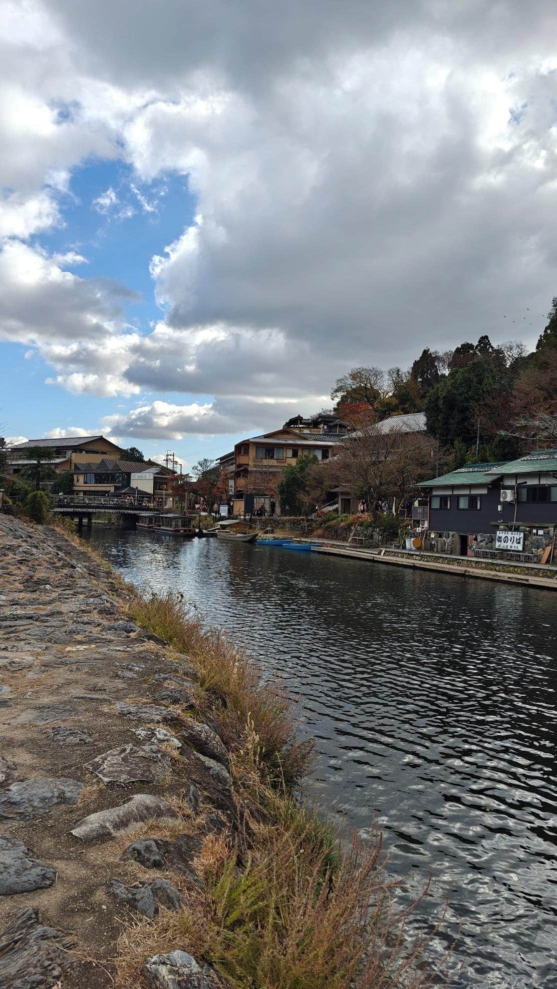 River with boats and traditional buildings under cloudy sky