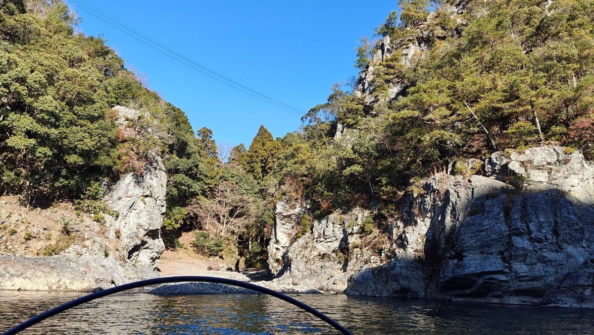 Rocky gorge with trees under clear blue sky