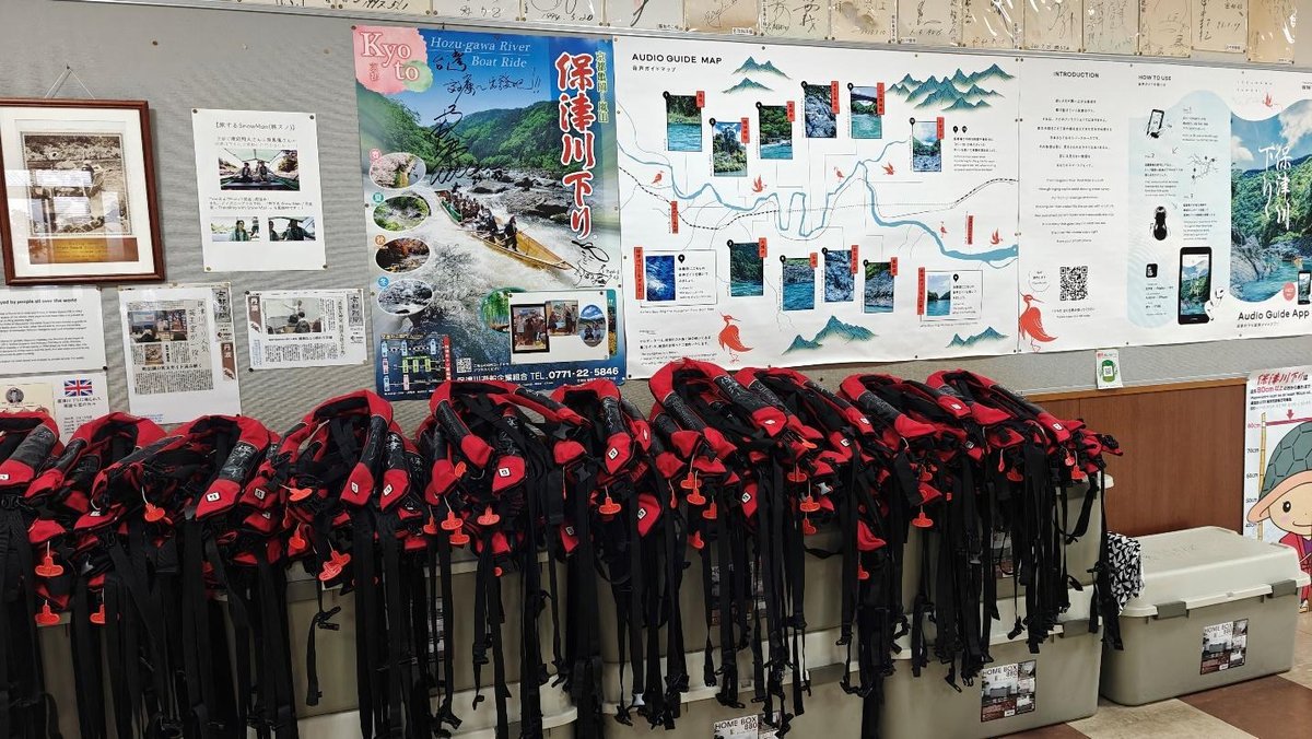 Row of life jackets below posters about Kyoto boat tours.