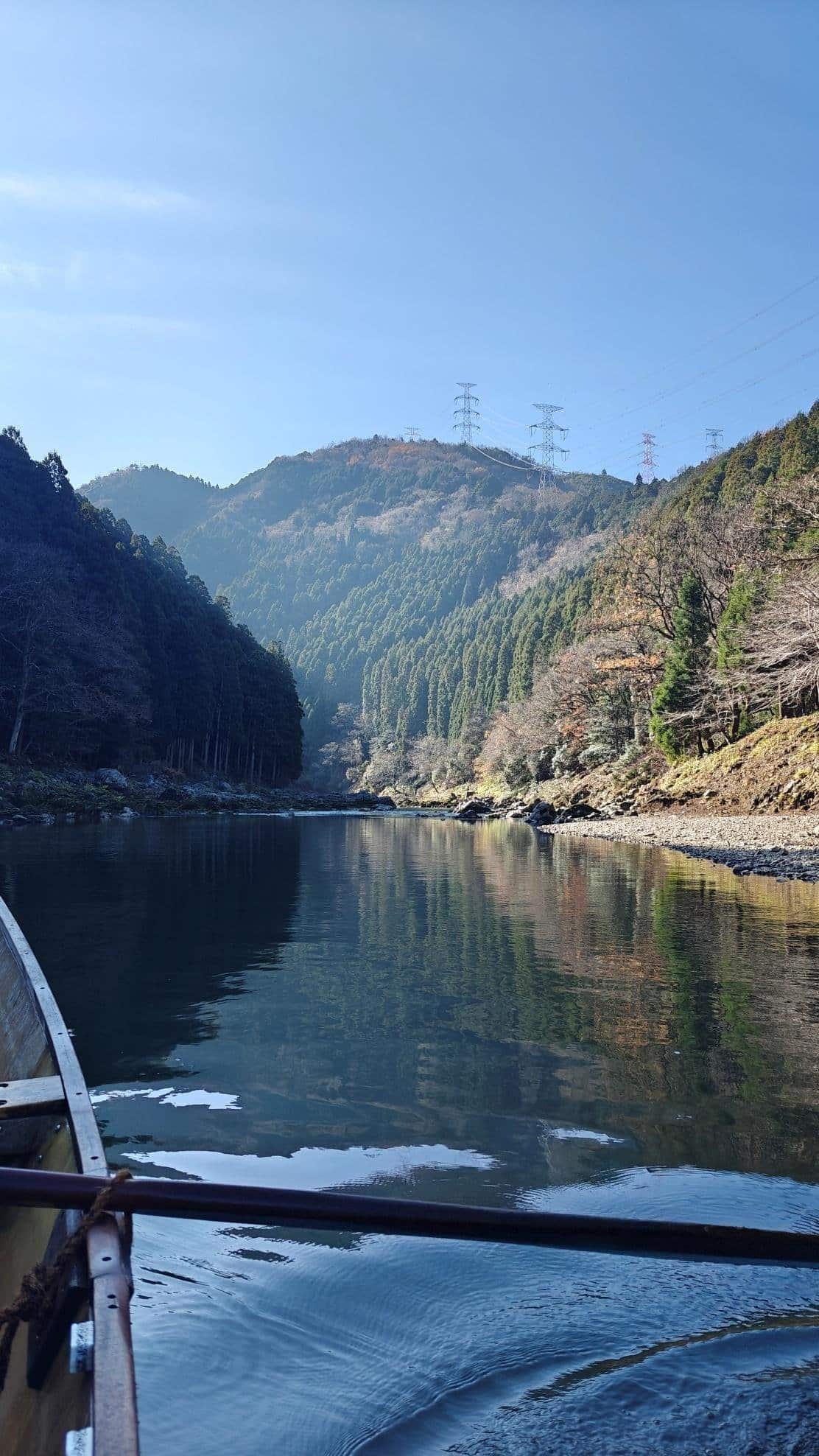 Scenic river with a boat, surrounded by forested hills