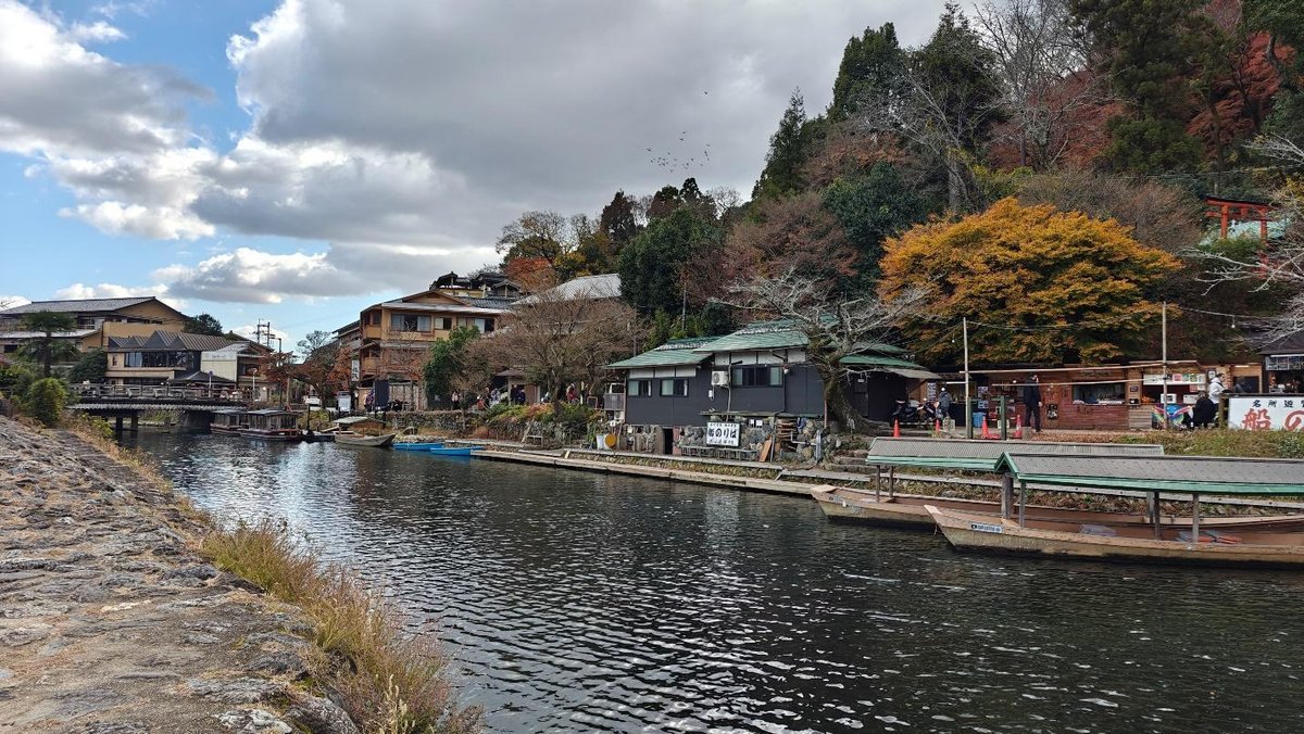 Scenic riverside village with boats and autumn trees