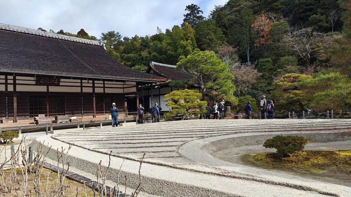 Serene Japanese garden with people and traditional building