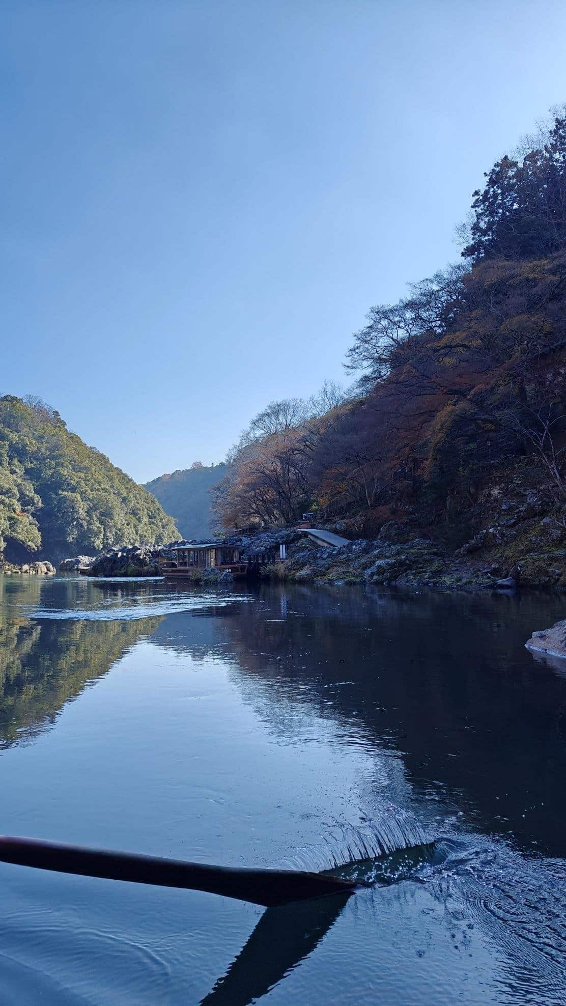 Serene river with autumn trees and clear blue sky