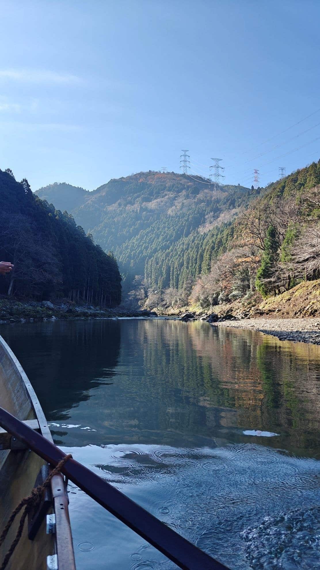 Serene river with forested hills under a clear blue sky