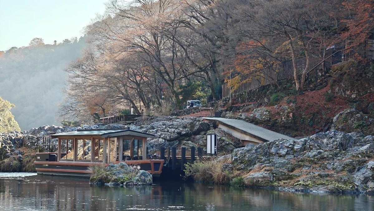 Serene riverside with boat and autumn trees