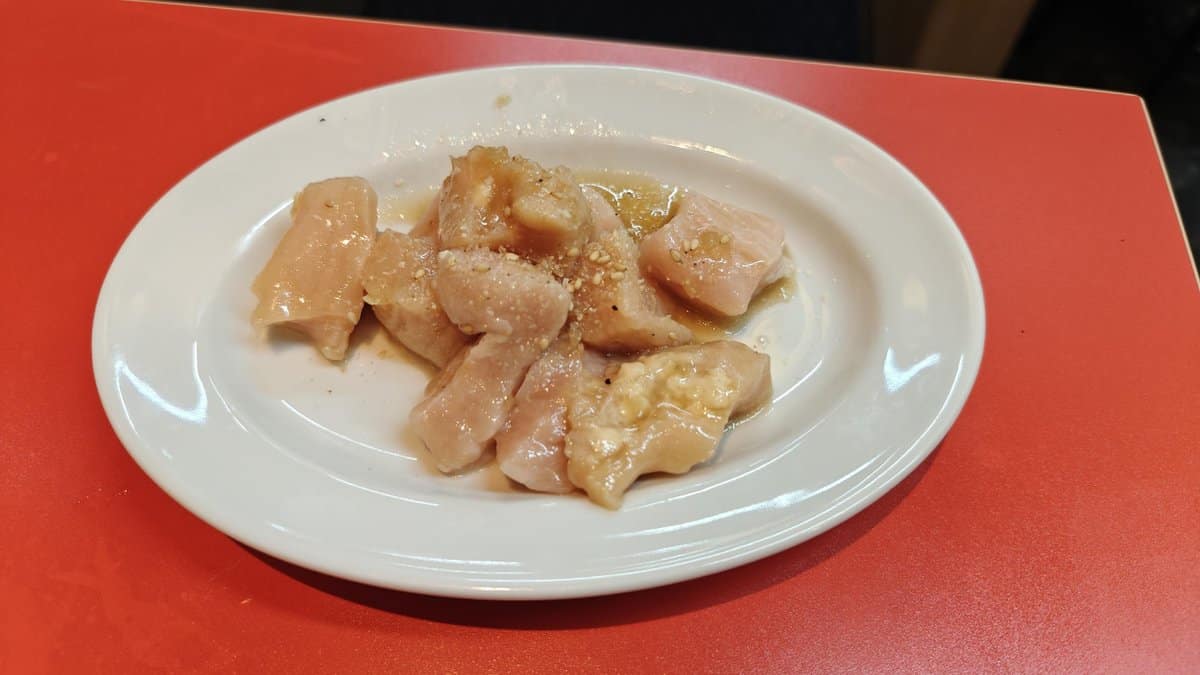 Sliced raw chicken on white plate