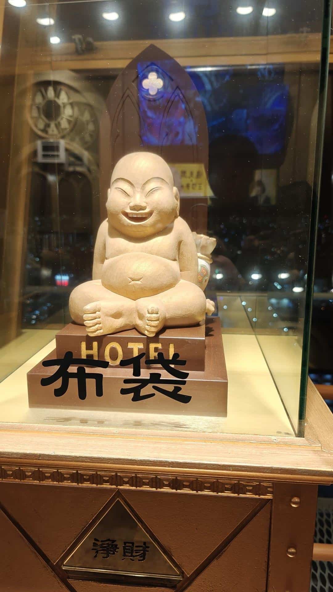 Smiling Buddha statue in glass case