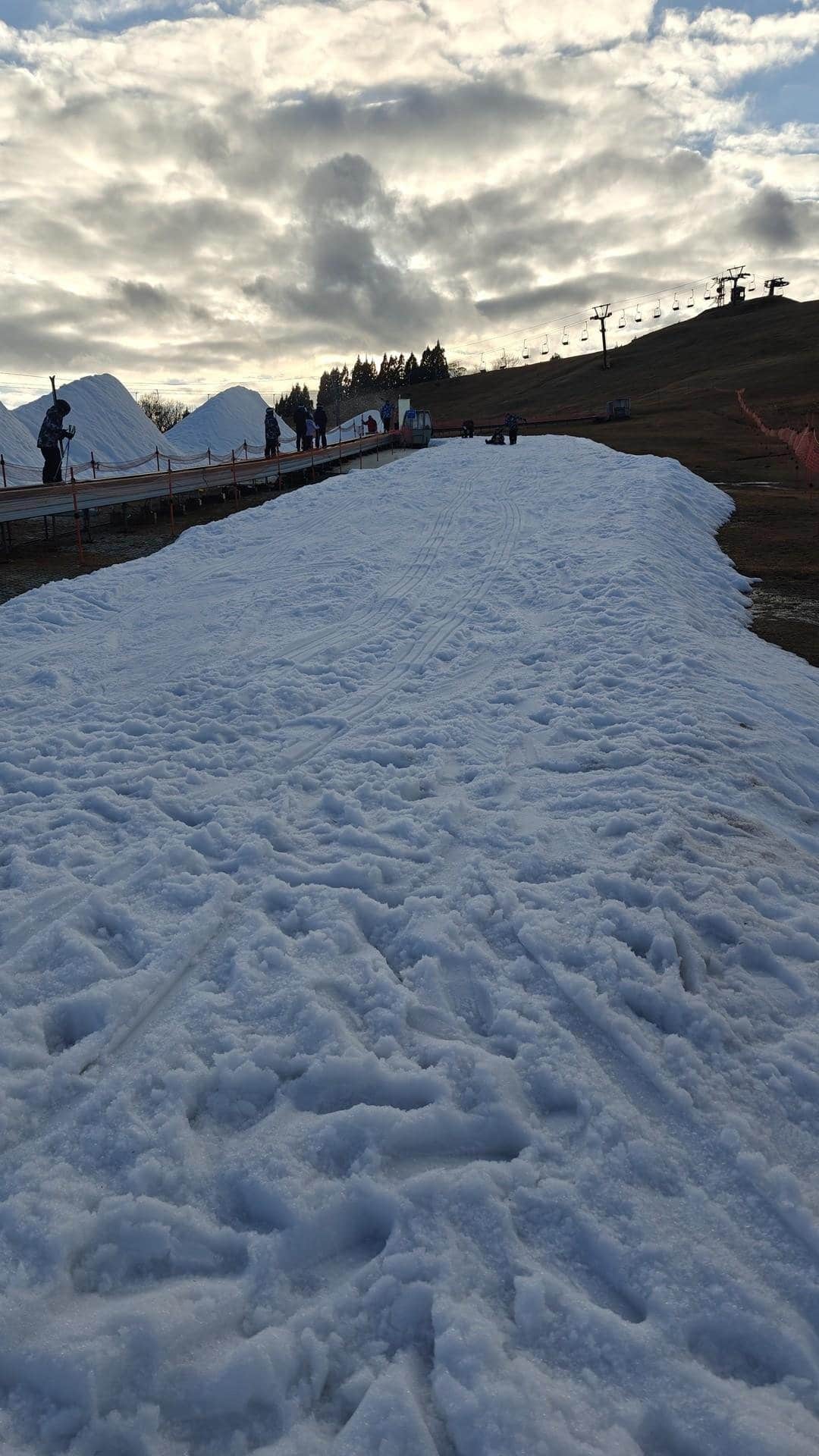 Snowy ski slope under cloudy sky