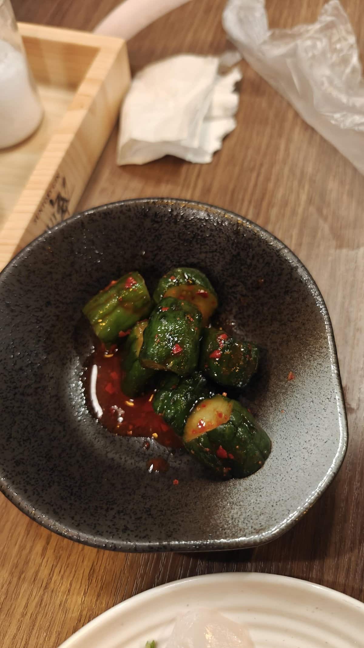 Spicy cucumber dish in black bowl