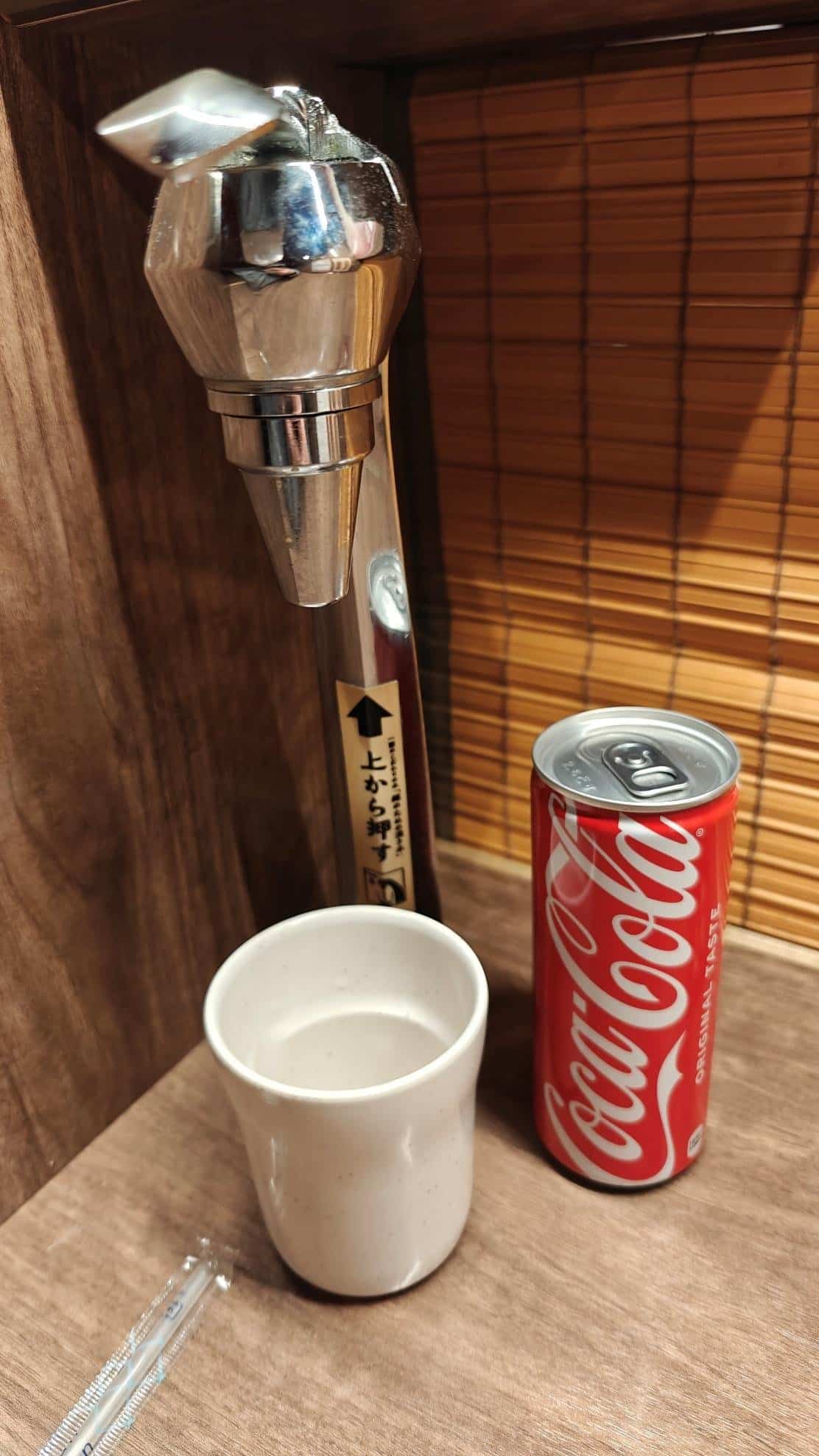Stainless tap with cup and Coca-Cola can