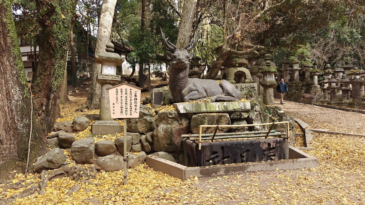 Stone deer statue in autumn forest