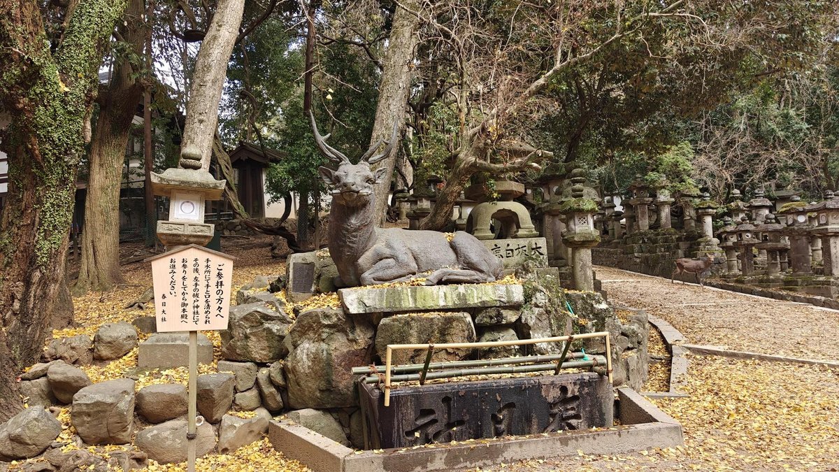 Stone deer statue in wooded shrine area