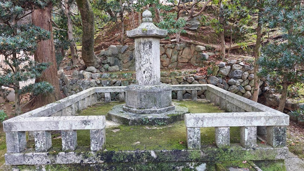 Stone monument in wooded area with mossy ground