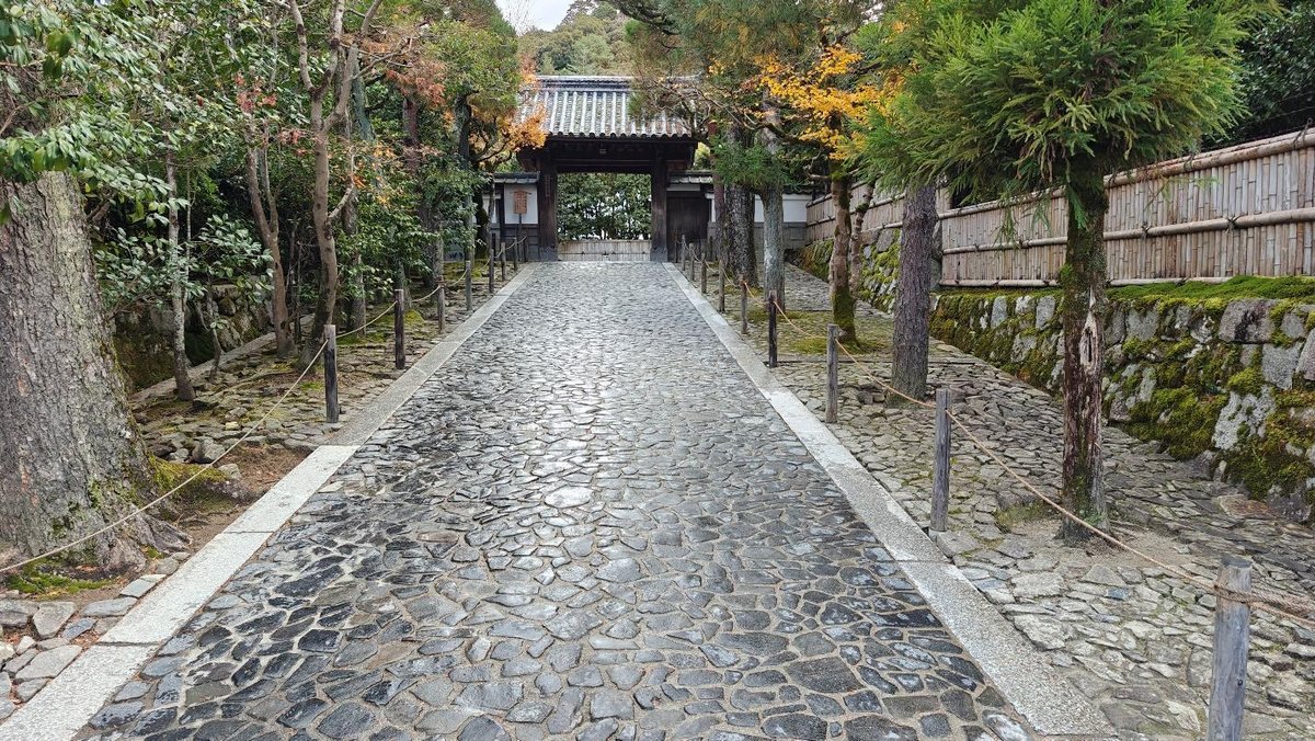 Stone path leading to Japanese temple gate with trees