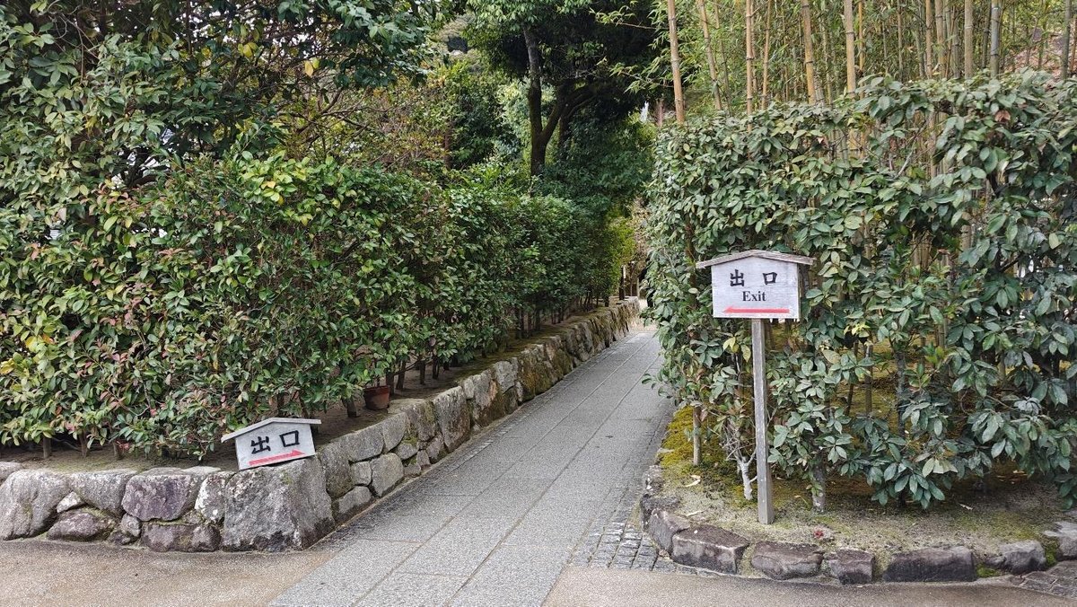 Stone path with greenery and exit signs in a garden