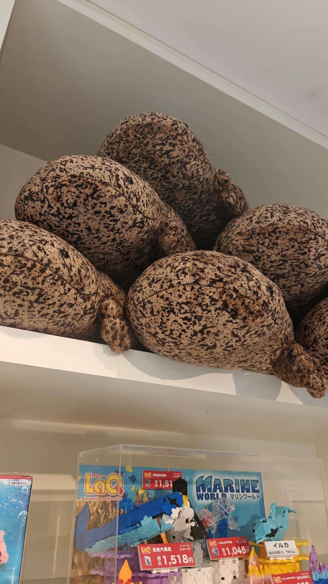 Stuffed toy pile above display of Japanese toy sets