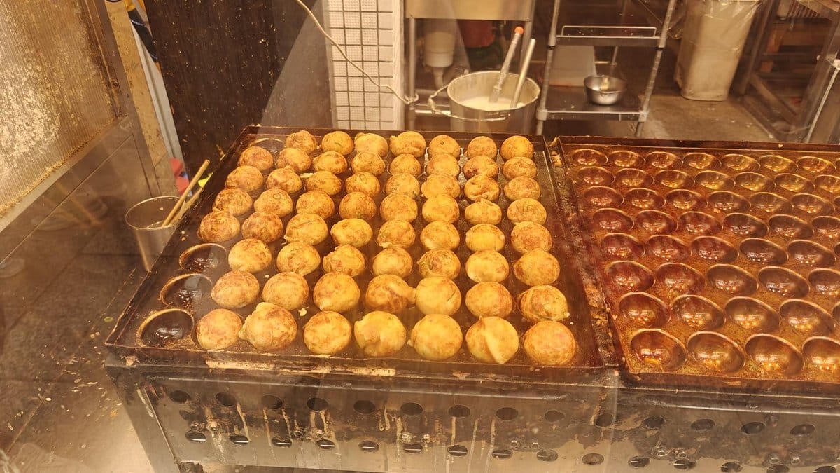 Takoyaki cooking on a hot griddle