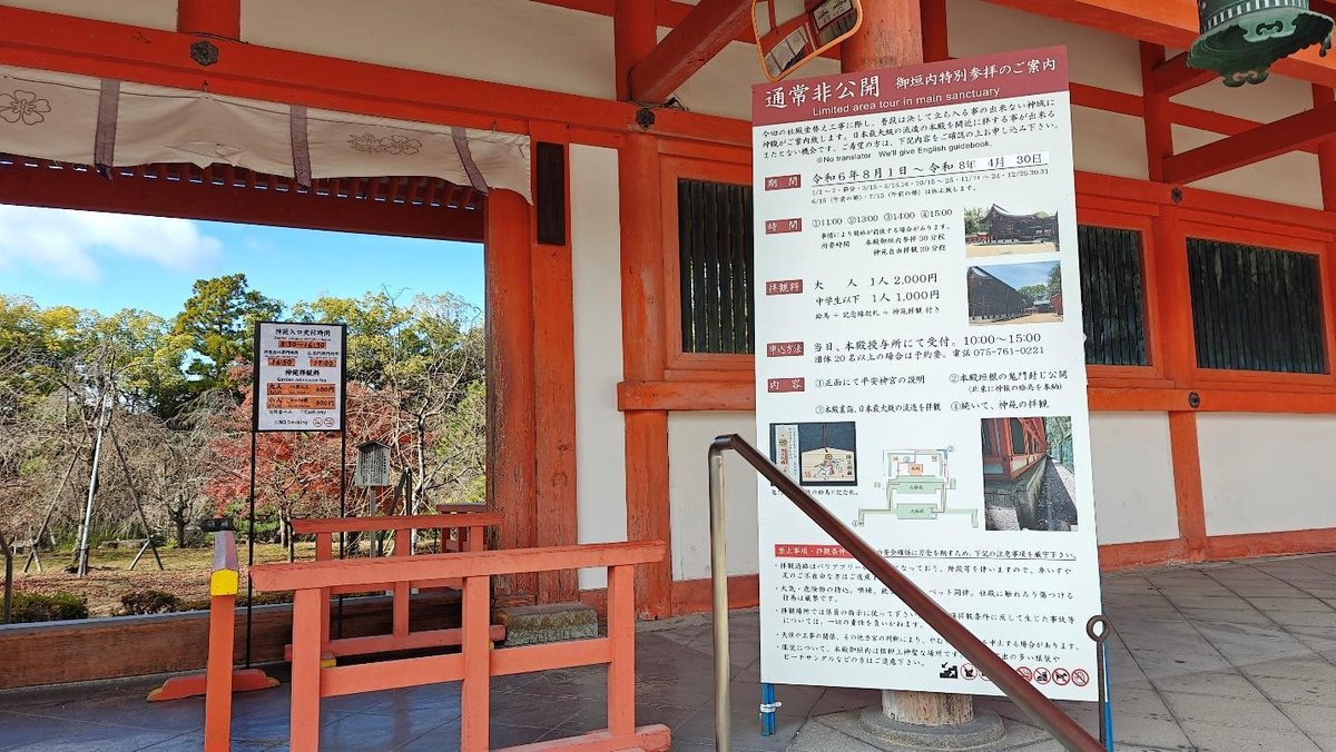 Temple entrance with informational signage and trees beyond
