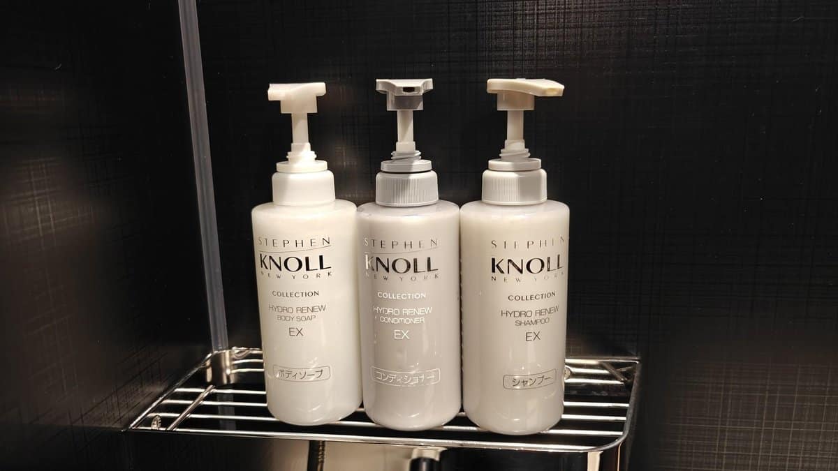 Three white shampoo bottles on shelf