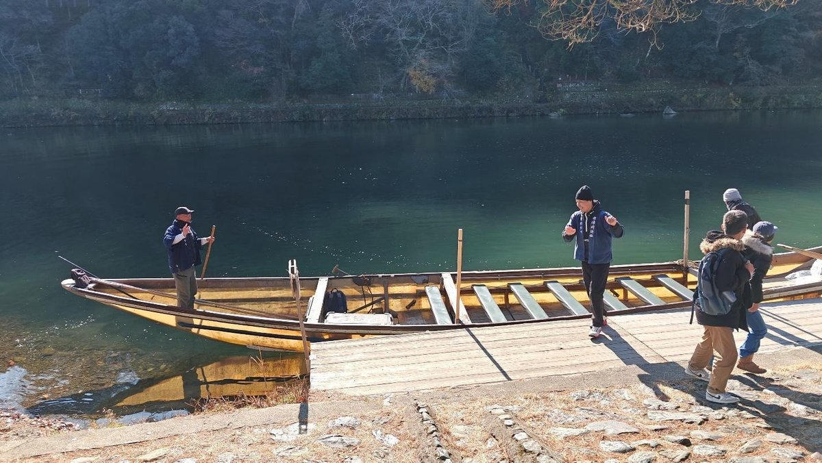 Tourists boarding wooden boat on serene river
