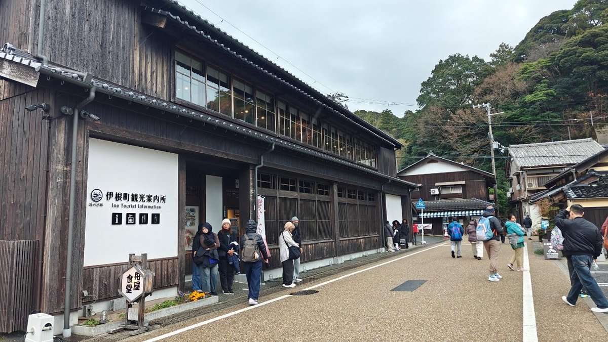 Tourists near wooden building in Ine