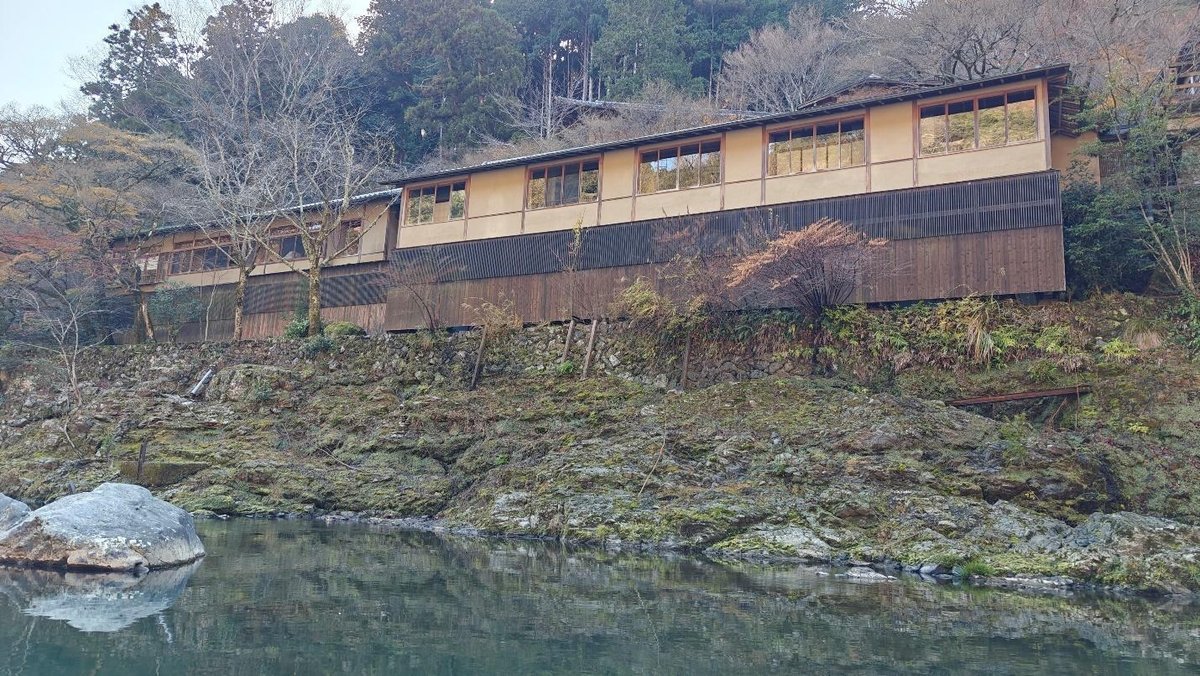 Traditional building by a calm river with trees
