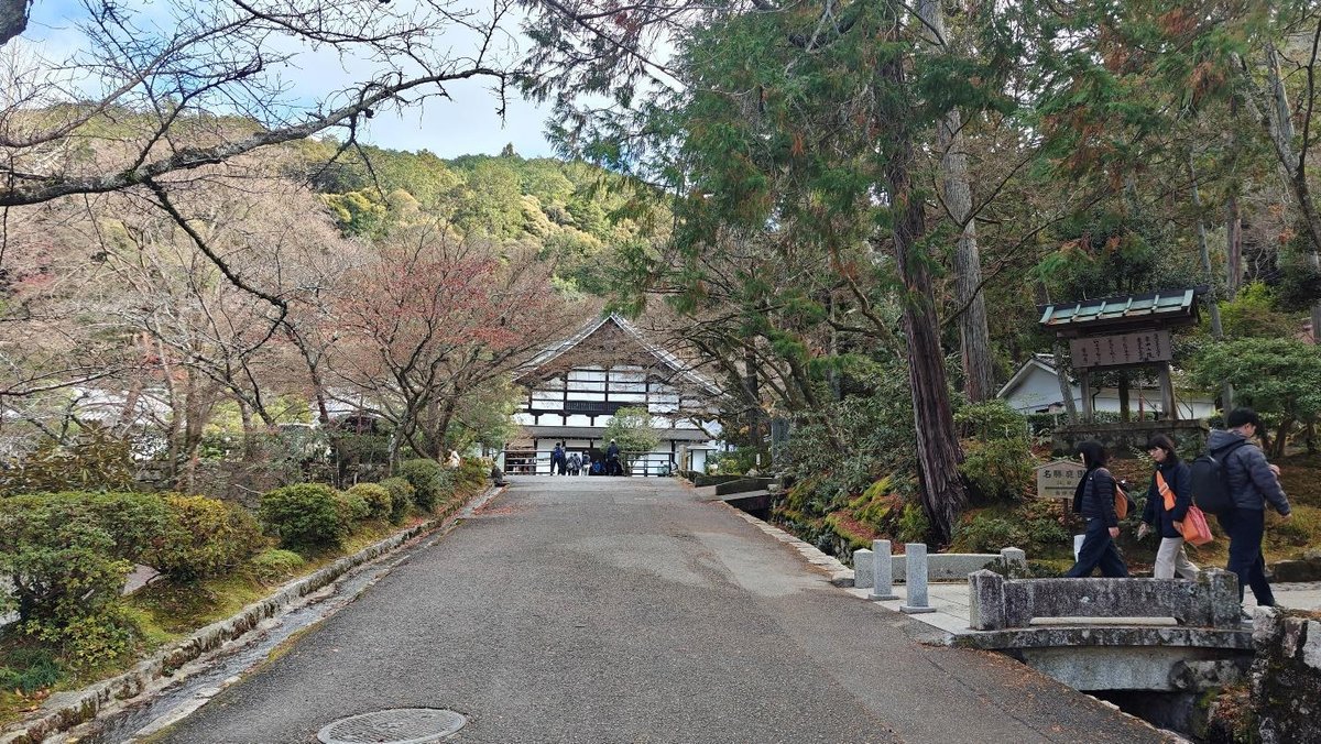Traditional Japanese building amidst lush trees and path