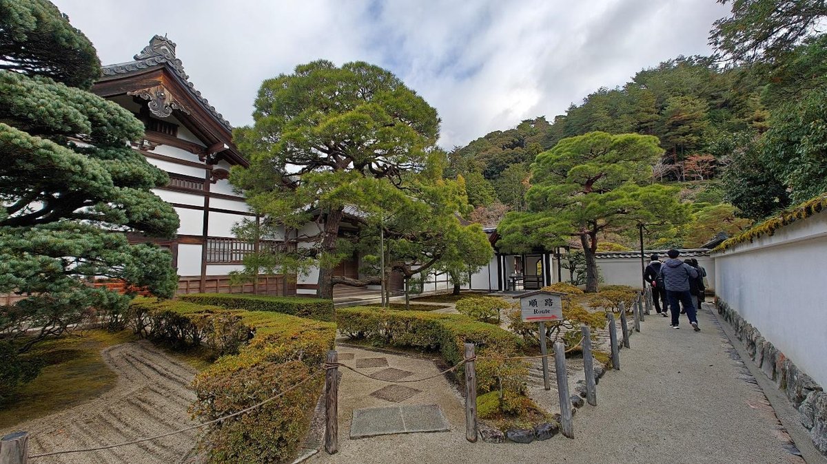 Traditional Japanese garden with trees, people walking on path