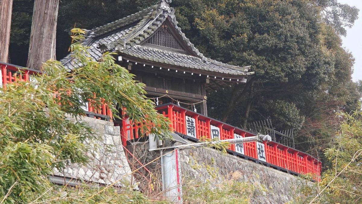 Traditional Japanese gate with red fence among trees