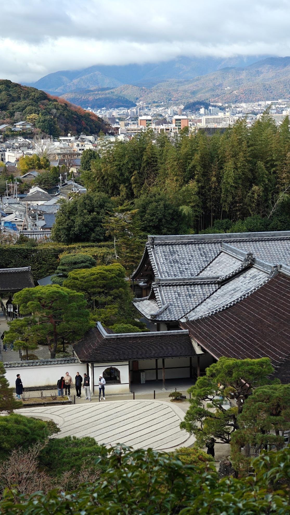 Traditional Japanese rooftop with city and mountains in background