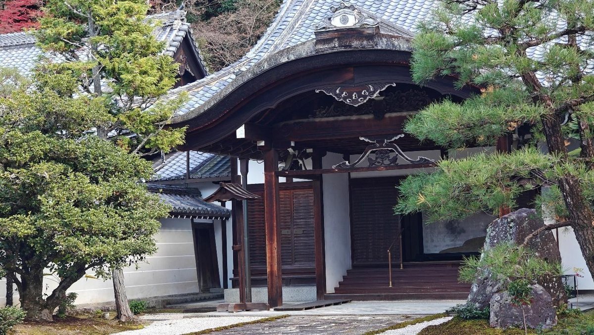 Traditional Japanese temple entrance with lush greenery