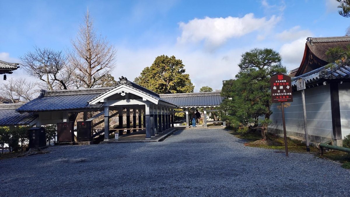 Traditional Japanese temple with blue-tiled roofs and trees
