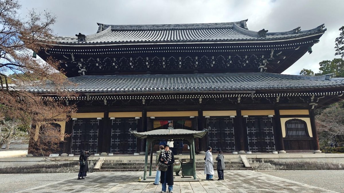 Traditional Japanese temple with visitors on a cloudy day